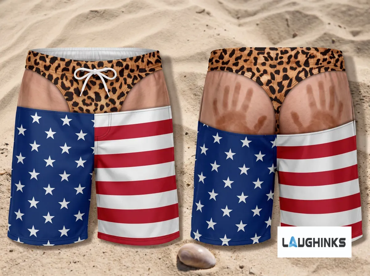 American Flag Leopard Print Funny Handprint Swim Trunks AOP Hawaiian Shorts for Men 7 Back view of American flag swim trunks with realistic handprint graphic on the seat, beach background.